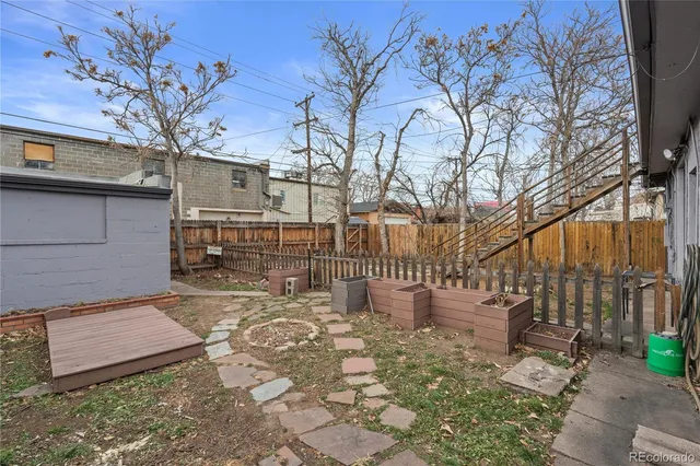 a view of a yard with plants and wooden fence