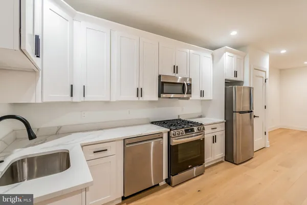 a kitchen with stainless steel appliances granite countertop a sink stove and microwave
