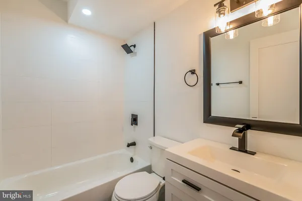 a bathroom with a sink a toilet a mirror and shower