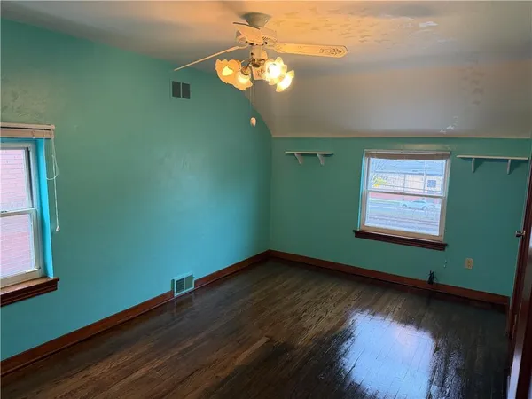 a view of a room with wooden floor and windows