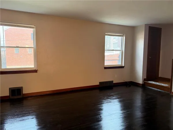 a view of an empty room window and wooden floor