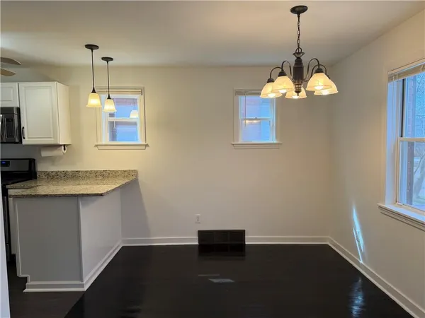 a view of a kitchen with a sink and dishwasher with wooden floor