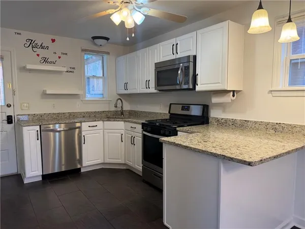 a kitchen with white cabinets appliances and a sink