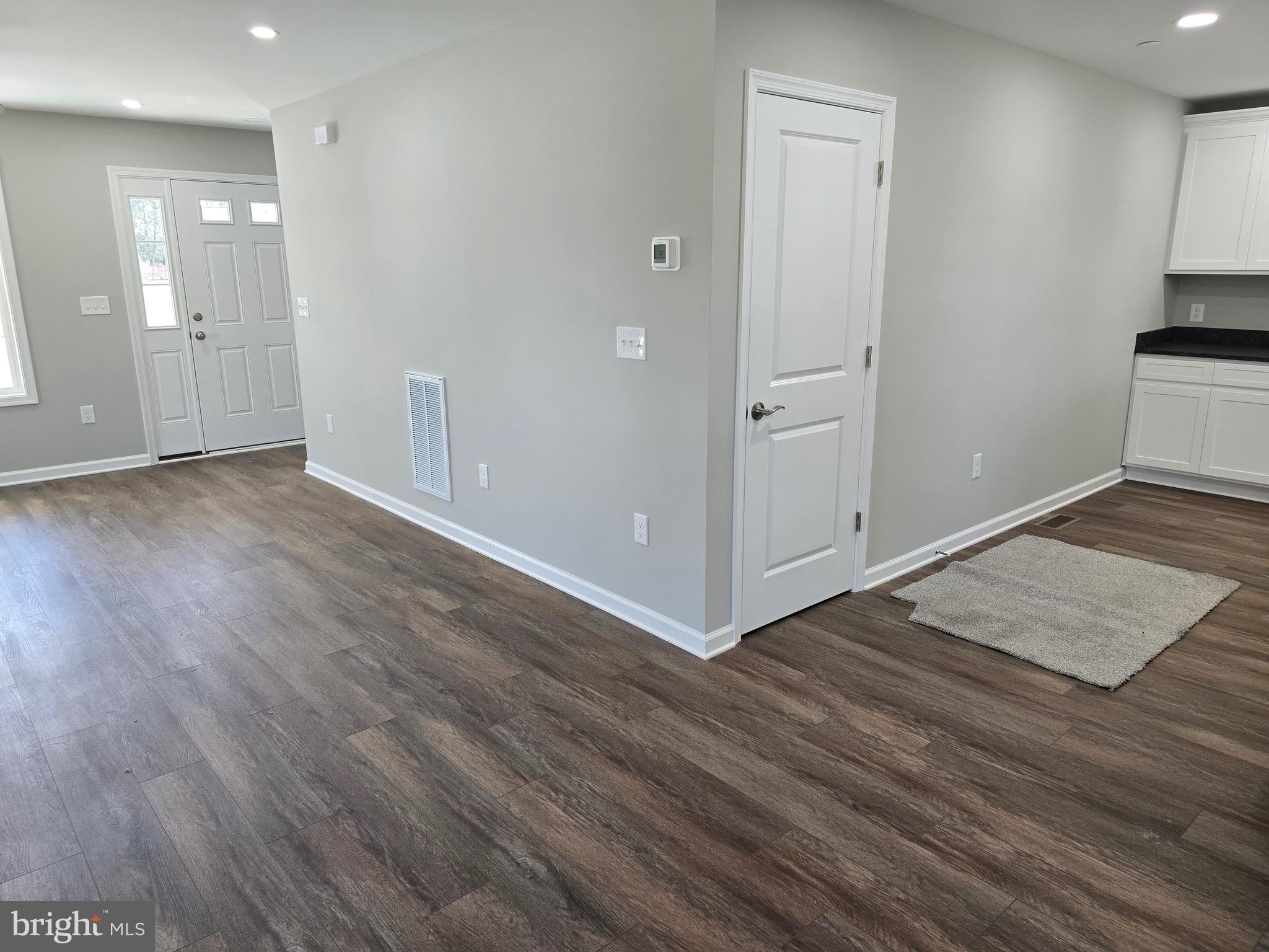 7457 Market Street Willards, MD 21874 - Photo 14 of 51 an empty room with wooden floor & cabinet and a sink
