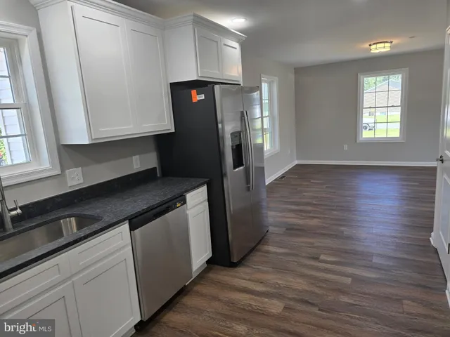 a kitchen with stainless steel appliances a refrigerator and wooden floor