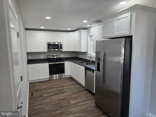 a kitchen with stainless steel appliances granite countertop a stove a refrigerator and a sink