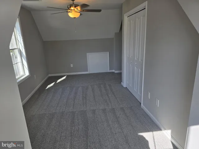 a view of empty room with window and wooden floor
