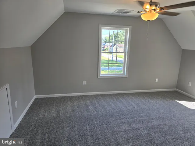 an empty room with window and chandelier fan