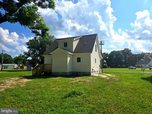 a view of a house with a big yard and a large tree