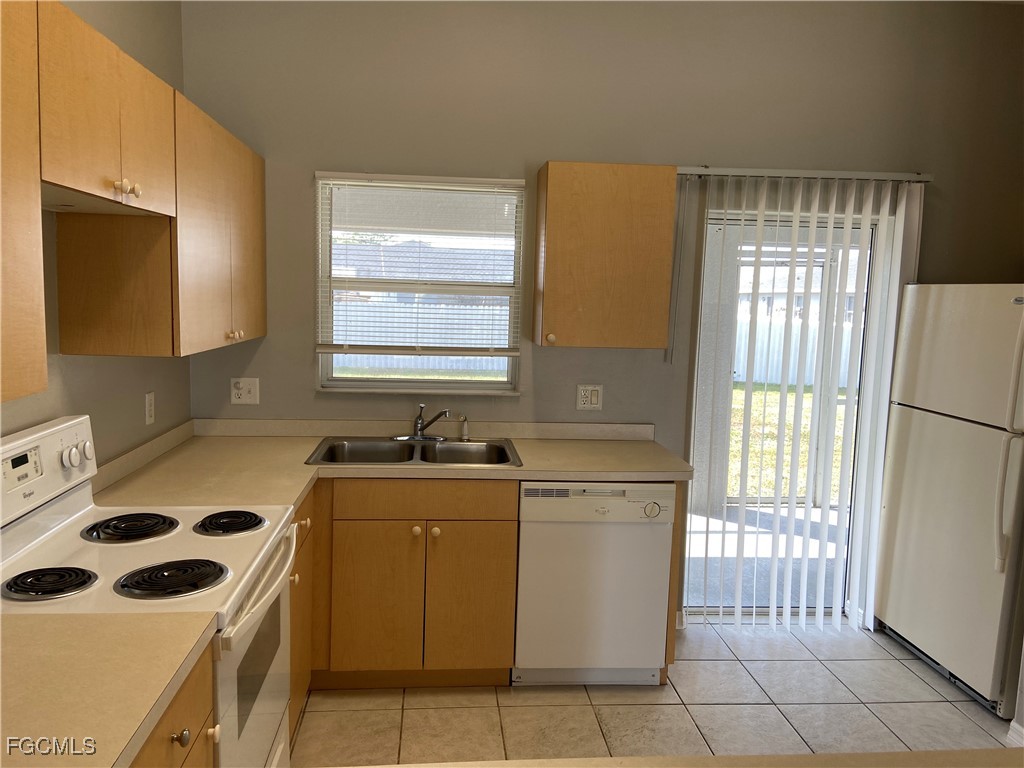 4543 20th Street Southwest Lehigh Acres, FL 33973 - Photo 8 of 19 a kitchen with a stove a sink and a refrigerator