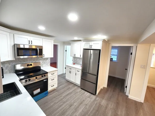a kitchen with white cabinets and stainless steel appliances