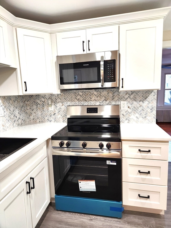 41 Bridgeport Street Worcester, MA 01604 - Photo 19 of 37 a kitchen with stainless steel appliances a stove a microwave and a sink