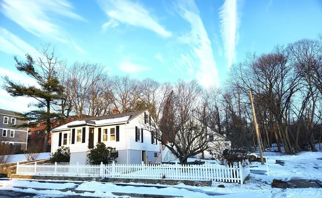 a front view of residential houses with yard and trees