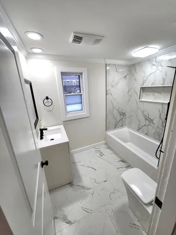 a bathroom with a tub sink and mirror