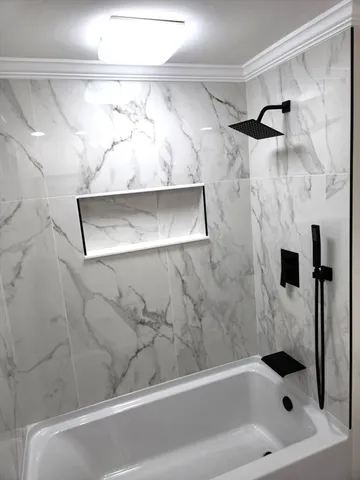 a bathroom with a bathtub and shower