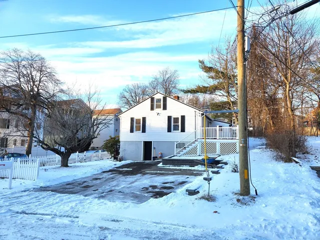 a view of a white house with a yard covered in snow