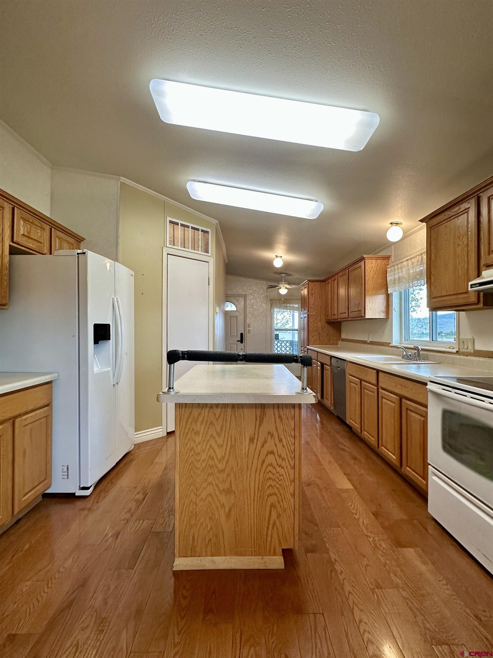 9427 2100th Road Austin, CO 81410 - Photo 16 of 42 a large kitchen with stainless steel appliances kitchen island granite countertop a refrigerator and a stove top oven
