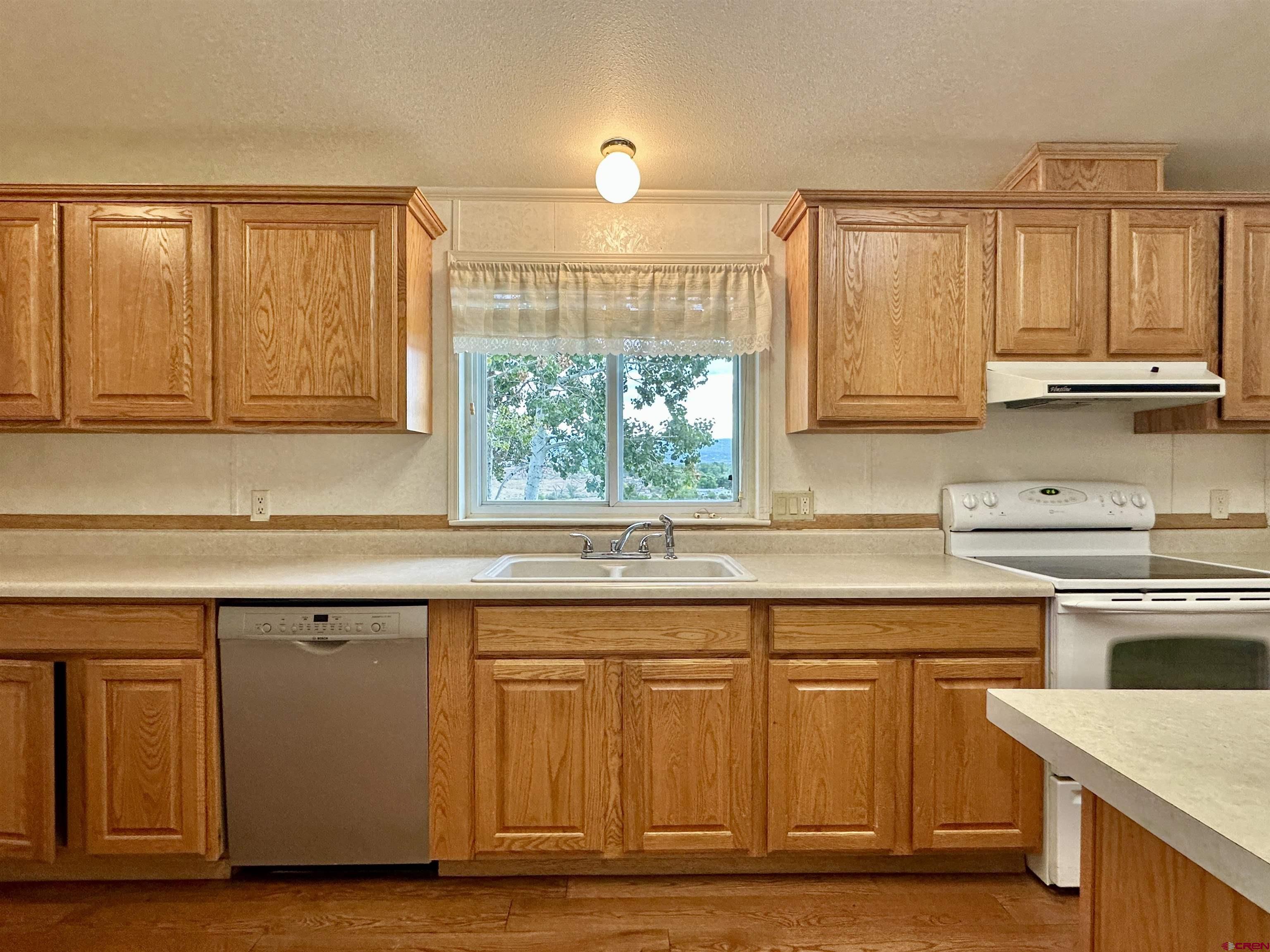9427 2100th Road Austin, CO 81410 - Photo 17 of 42 a kitchen with stainless steel appliances granite countertop a stove a sink and a microwave