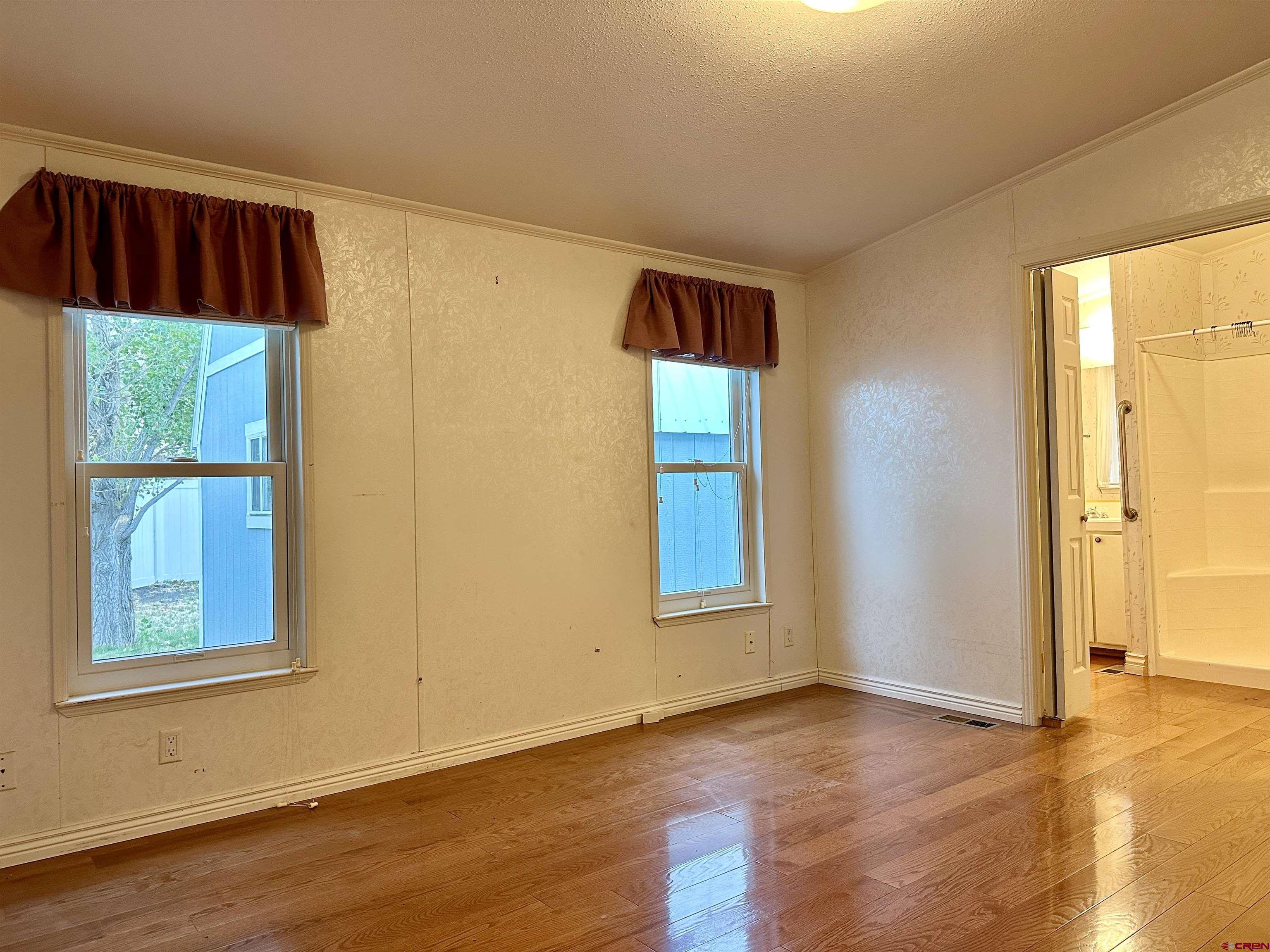9427 2100th Road Austin, CO 81410 - Photo 22 of 42 a view of an empty room with window and wooden floor
