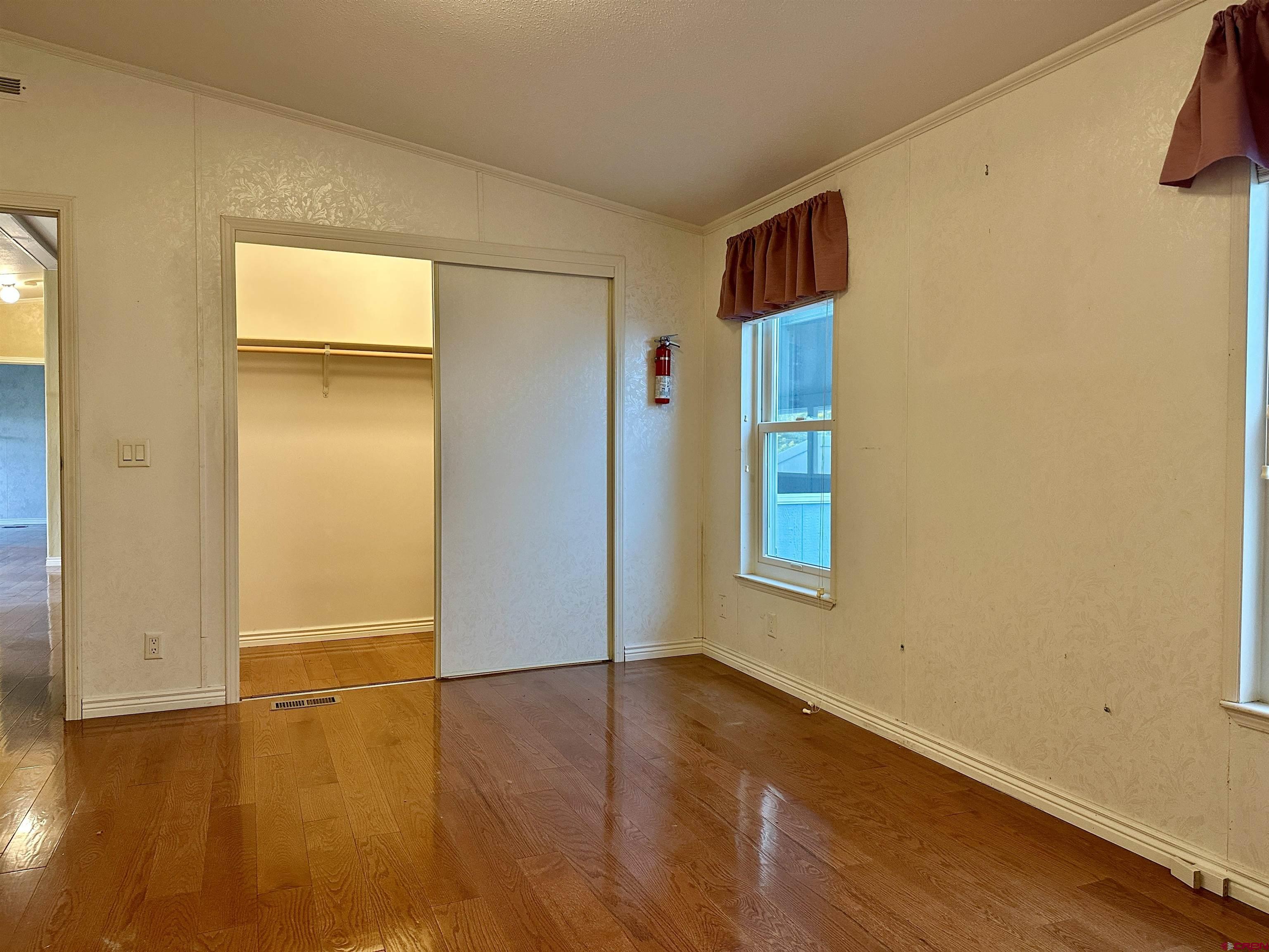 9427 2100th Road Austin, CO 81410 - Photo 23 of 42 an empty room with wooden floor and windows