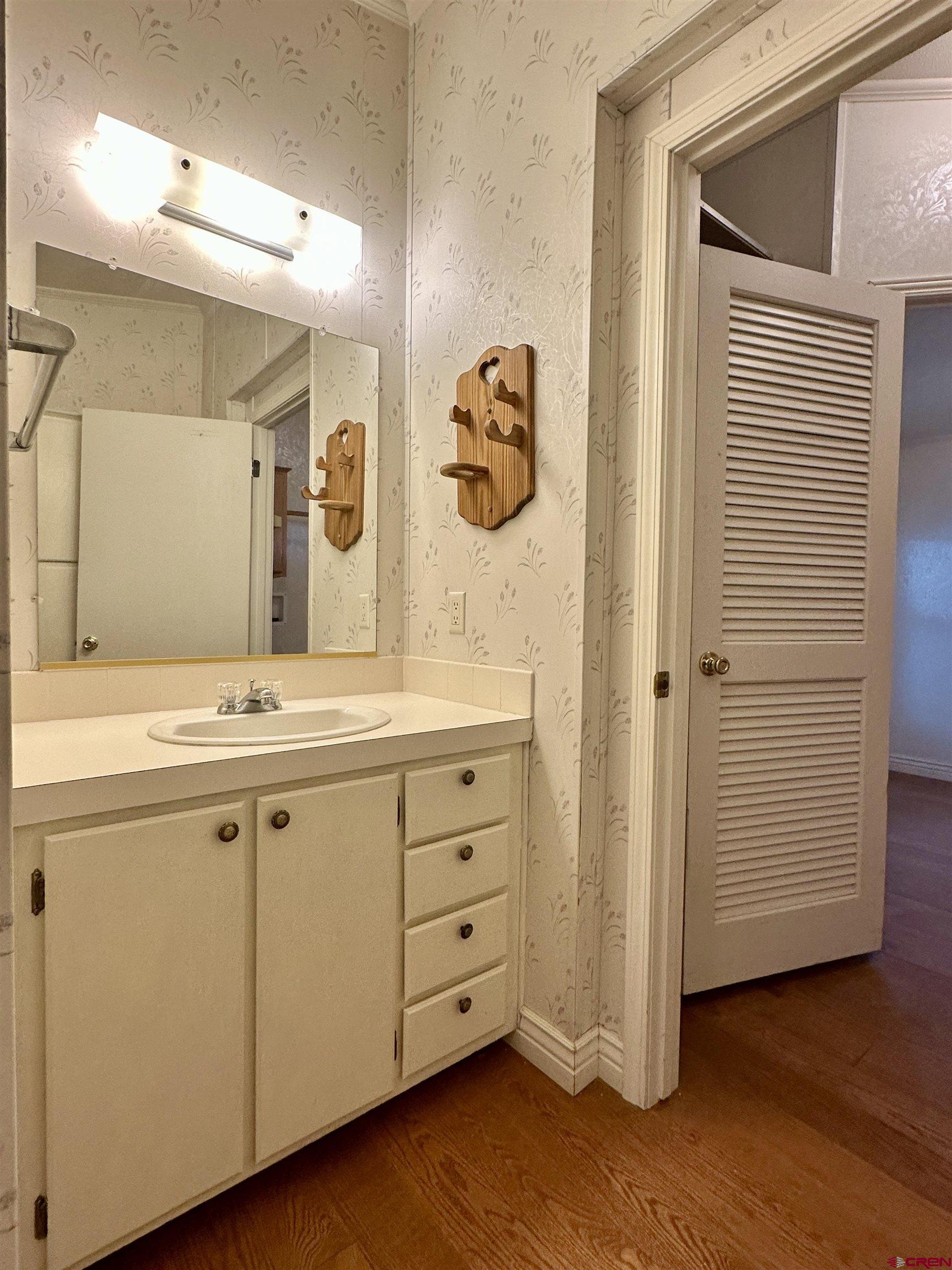 9427 2100th Road Austin, CO 81410 - Photo 26 of 42 a bathroom with a granite countertop sink a mirror and a bathtub