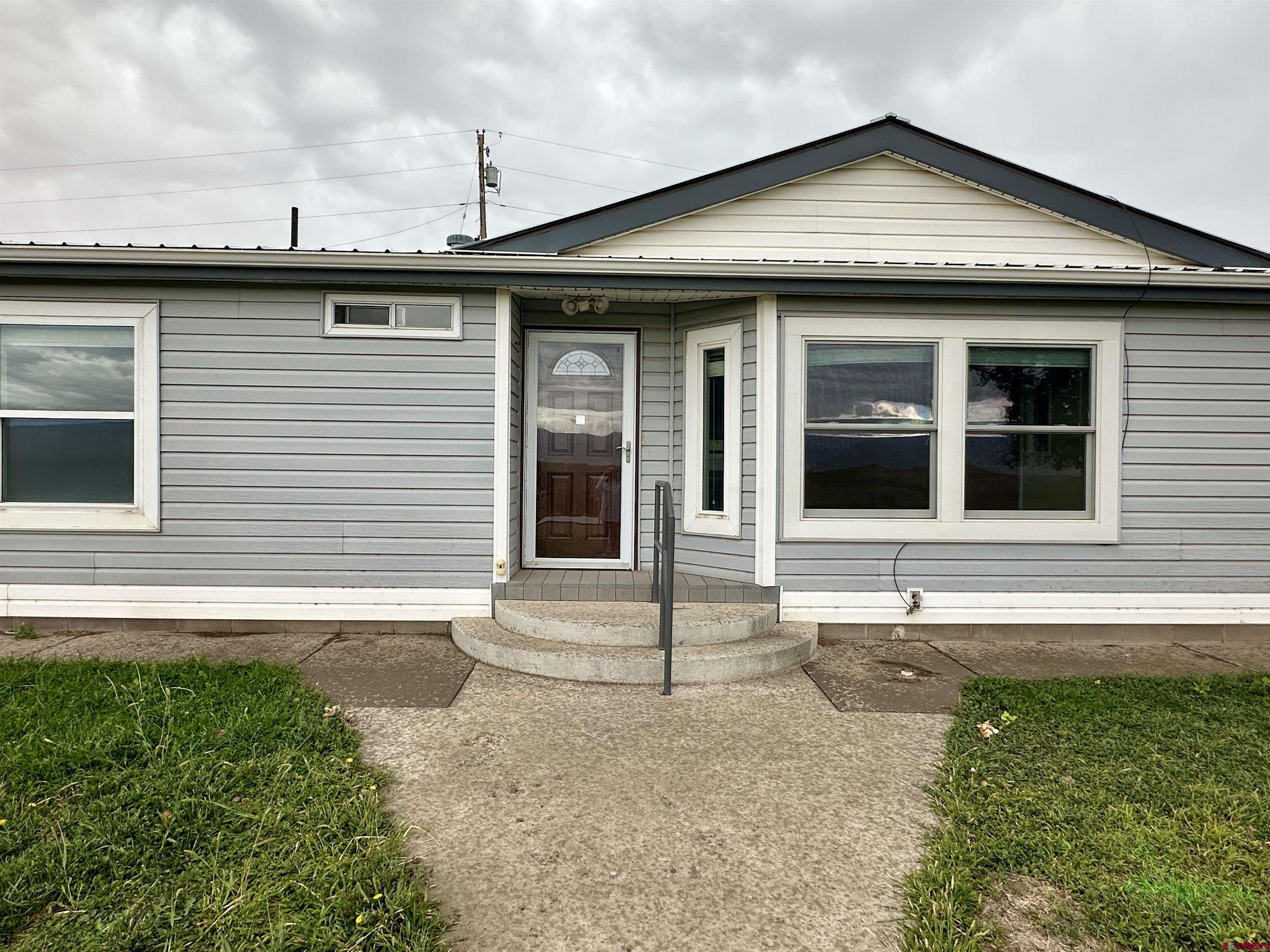 9427 2100th Road Austin, CO 81410 - Photo 3 of 42 a front view of a house with a garden