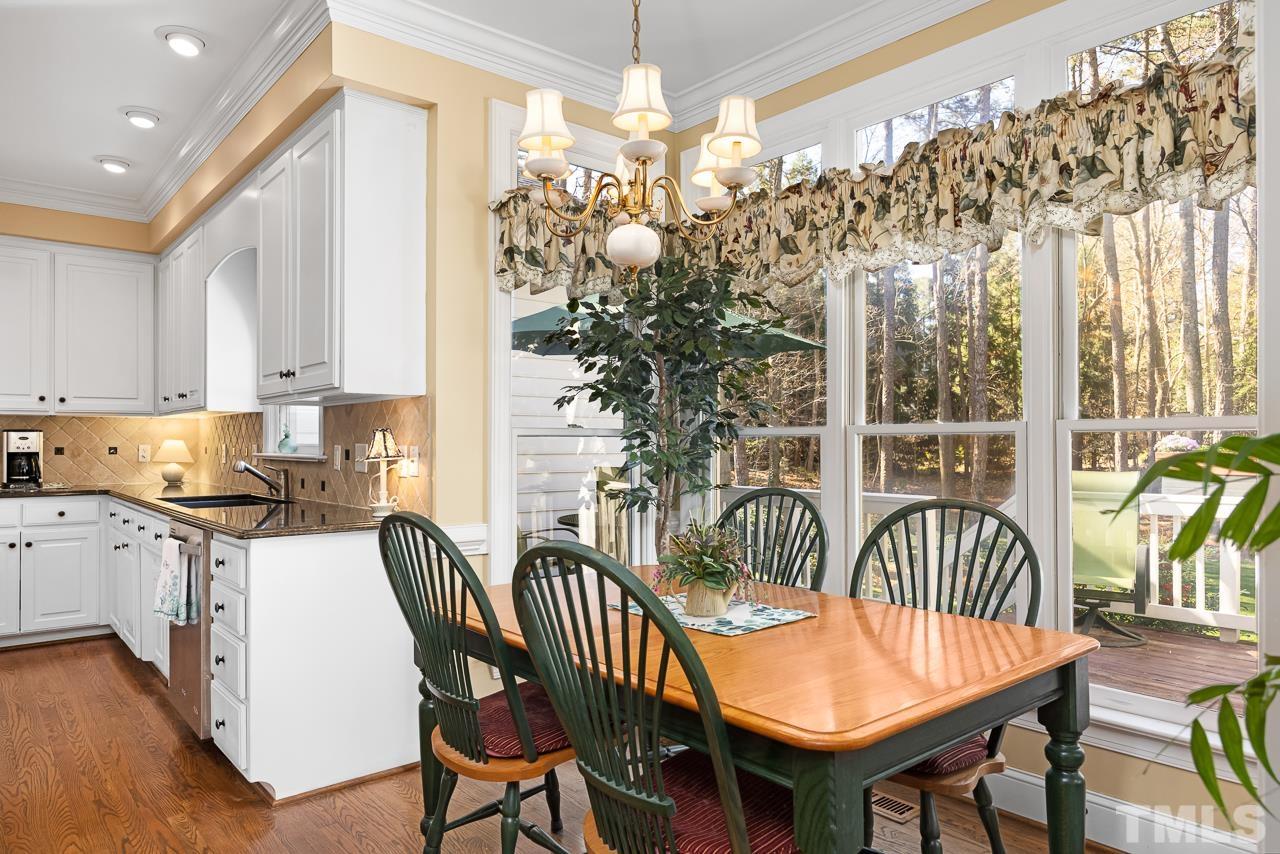301 Medoc Lane Raleigh, NC 27615 - Photo 12 of 55 a dining room with furniture a chandelier and wooden floor