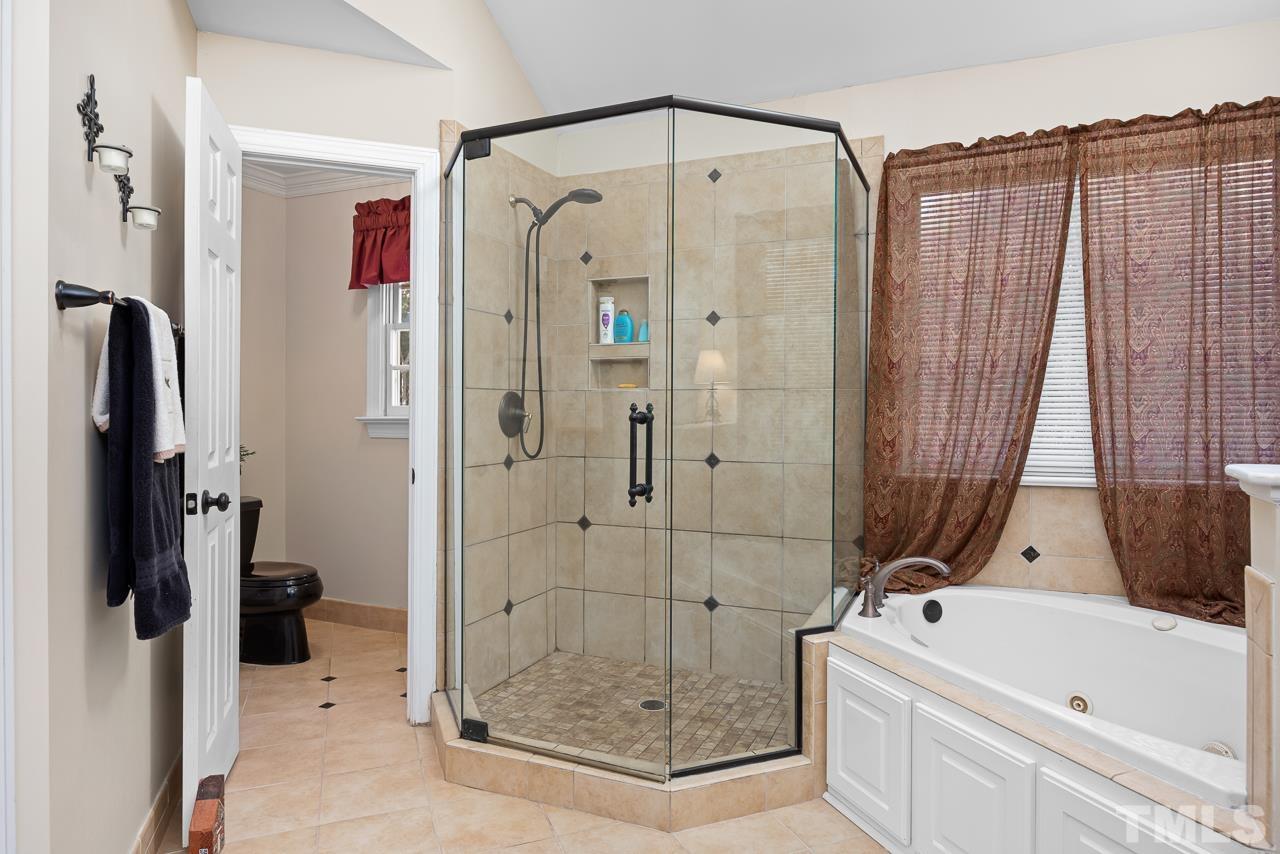 301 Medoc Lane Raleigh, NC 27615 - Photo 20 of 55 a bathroom with a tub and a shower