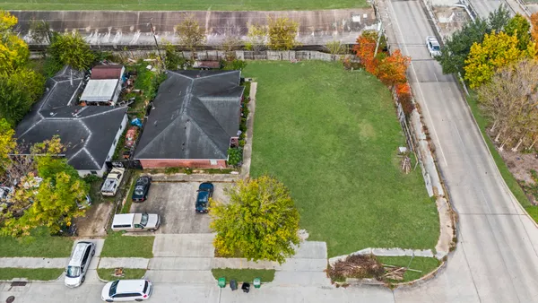 an aerial view of residential houses with outdoor space and trees