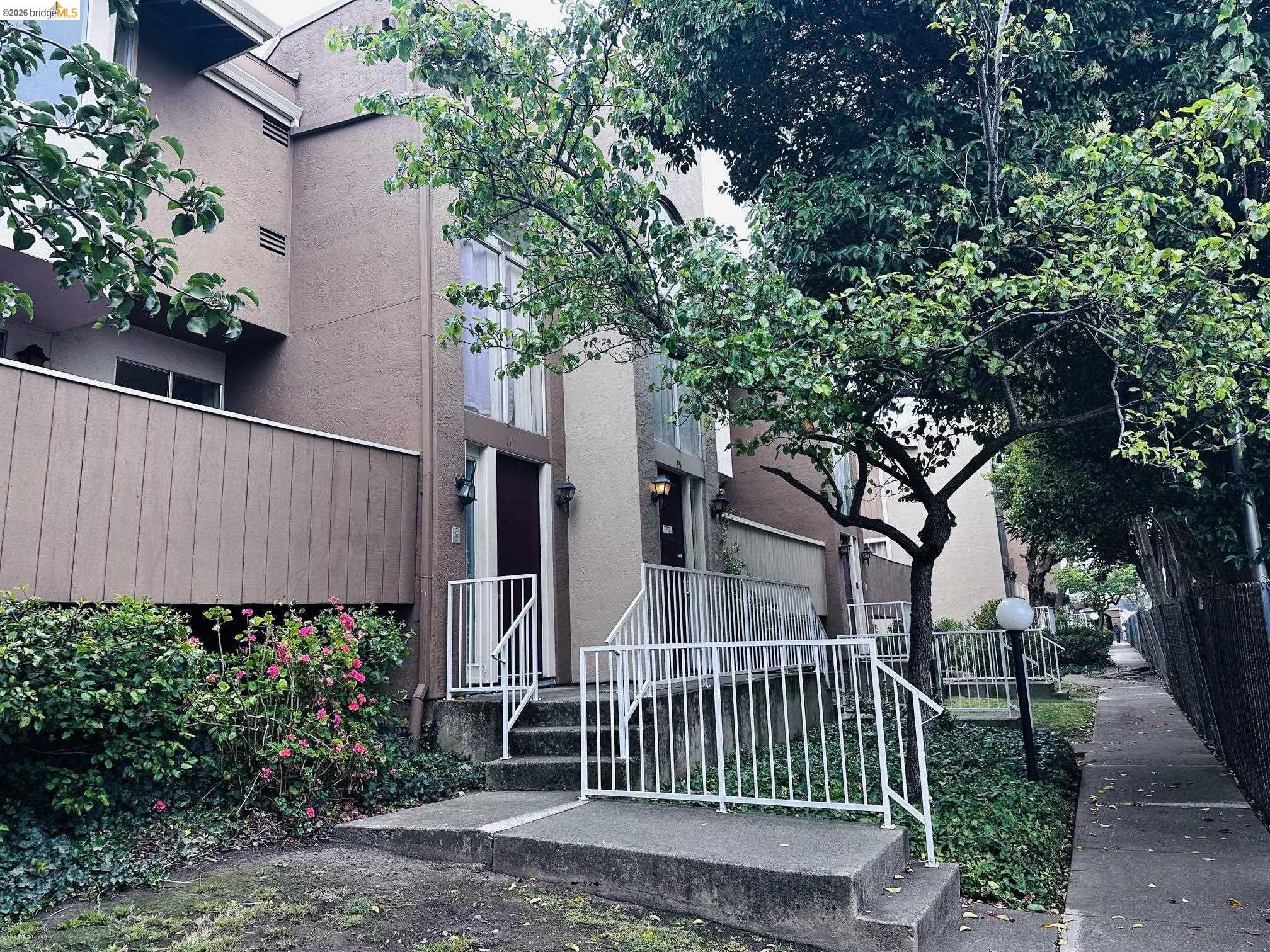 2121 Vale Road, Unit 17 San Pablo, CA 94806 - Photo 5 of 17 Exterior facade featuring a private balcony, ground-level entry, and established landscaping