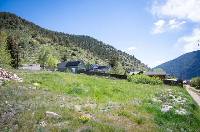 a view of a lush green outdoor space with swimming pool and valleys in the background