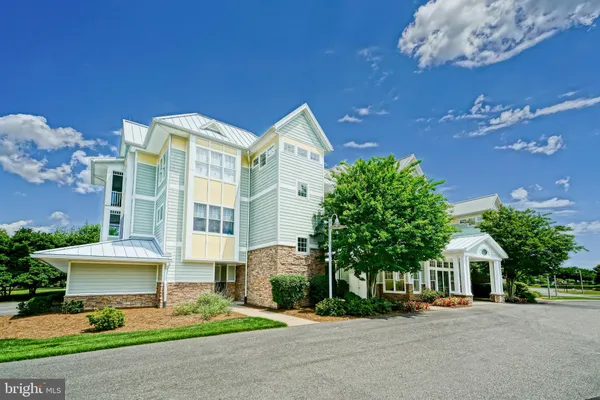 a front view of a building with a garden and plants