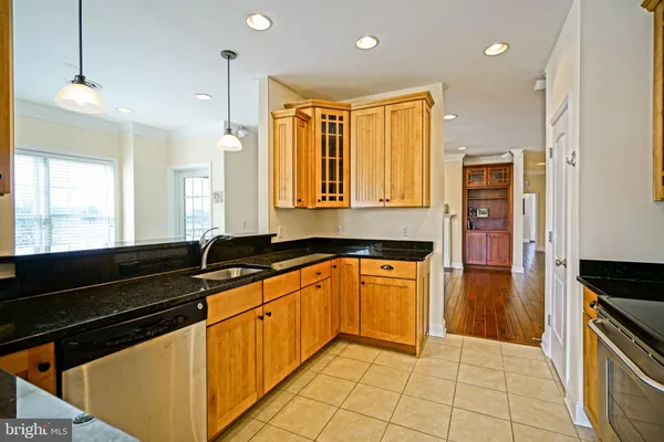 a kitchen with stainless steel appliances granite countertop a sink and a refrigerator