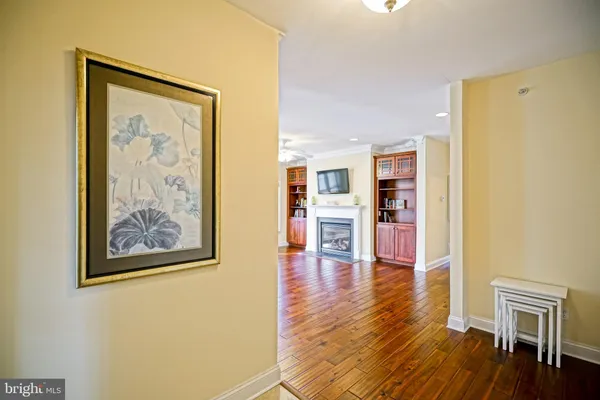 a view of a hallway with wooden floor and furniture