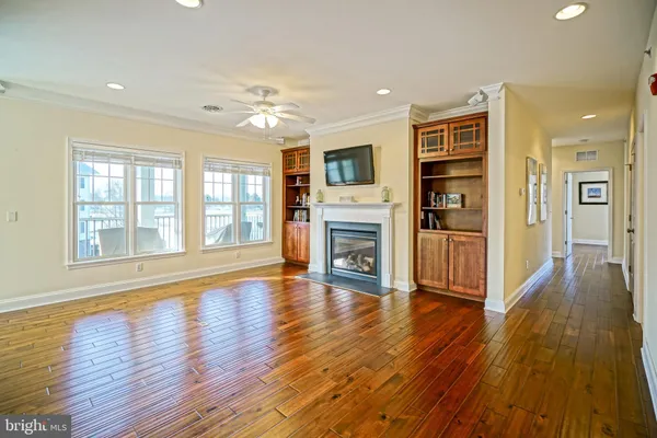 a view of empty room with wooden floor and fireplace