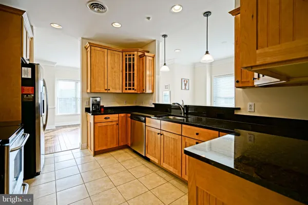 a kitchen with stainless steel appliances granite countertop a sink and a stove