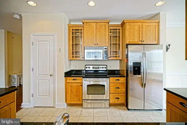 a kitchen with stainless steel appliances granite countertop a stove a refrigerator and a cabinets