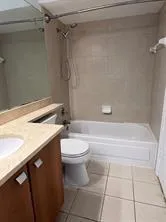 a bathroom with a granite countertop bathtub and toilet