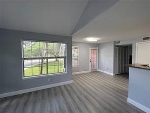 1001 Crystal Way, Unit B Delray Beach, FL 33444 - Photo 6 of 12 a view of an empty room with wooden floor and a window