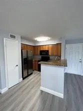 a view of kitchen with stainless steel appliances wooden floor and large window