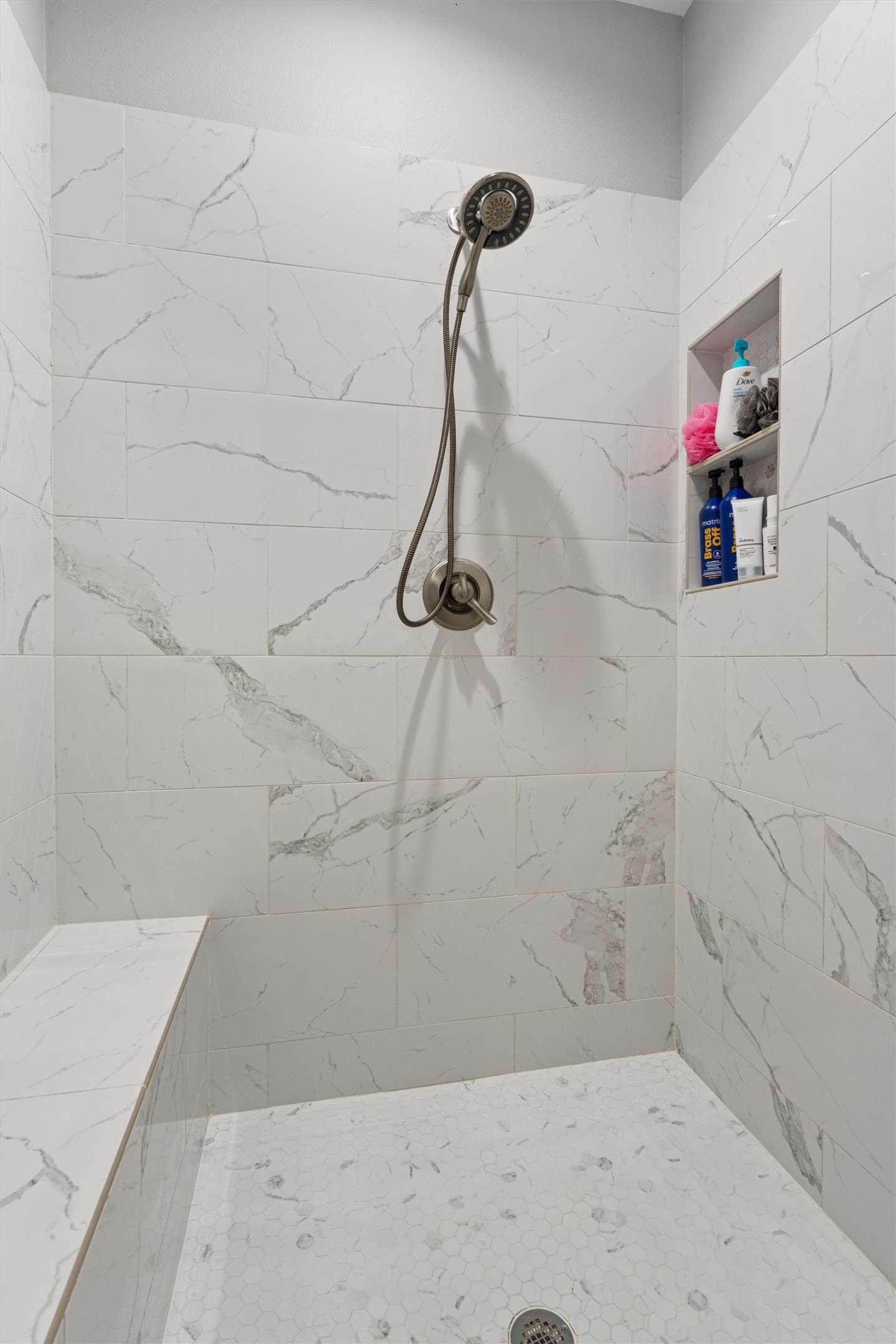 136 Fawn Hollow Elgin, TX 78621 - Photo 20 of 40 Walk in shower featuring a built-in bench, wall niche, and handheld shower fixture