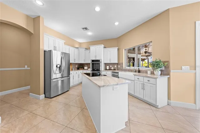 a spacious bedroom with a bed and a flat tv screen