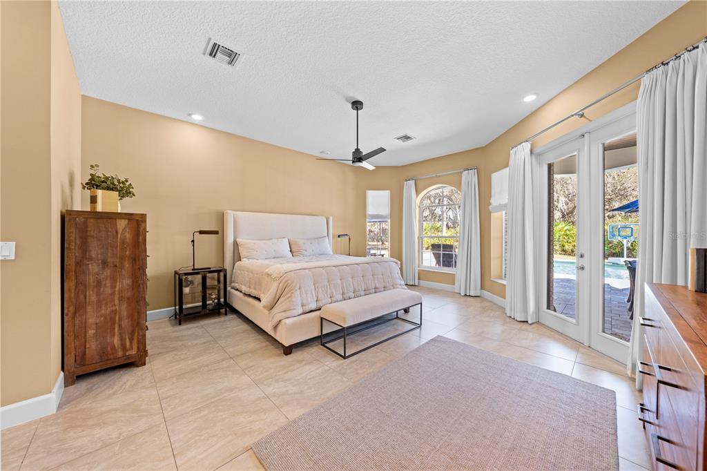 4231 Albritton Road St. Cloud, FL 34772 - Photo 35 of 94 a spacious bedroom with a large bed and a chandelier