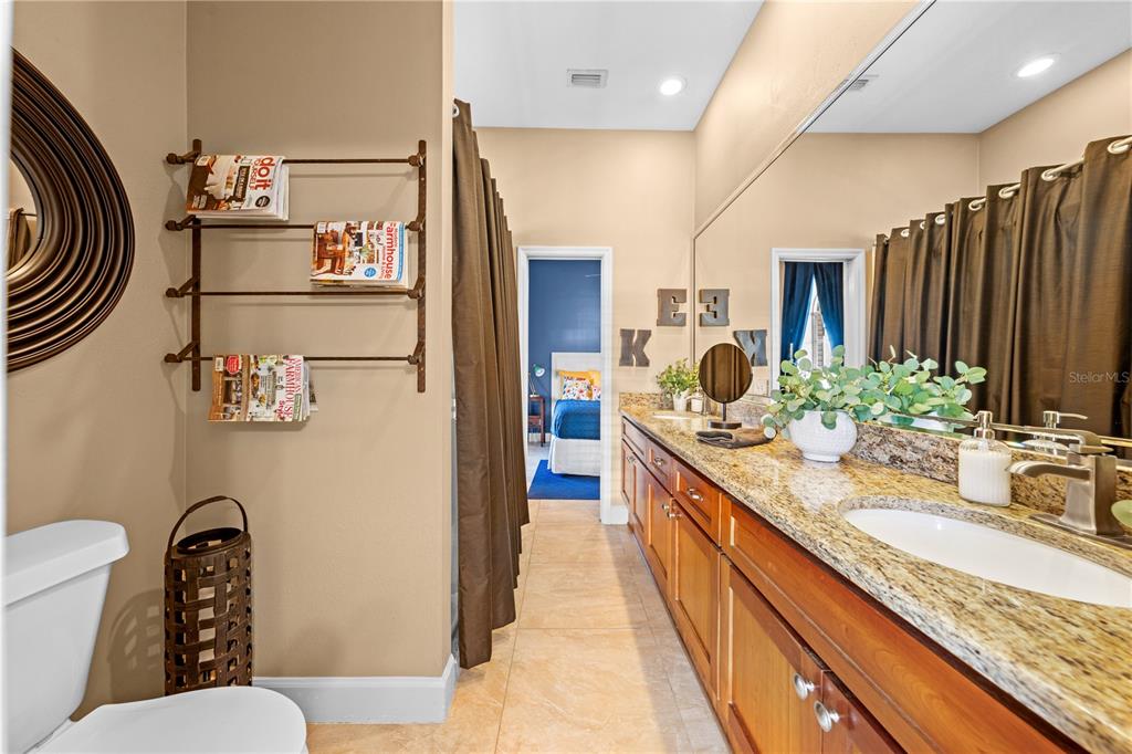 4231 Albritton Road St. Cloud, FL 34772 - Photo 50 of 94 a bathroom with a granite countertop sink a toilet a mirror and shower