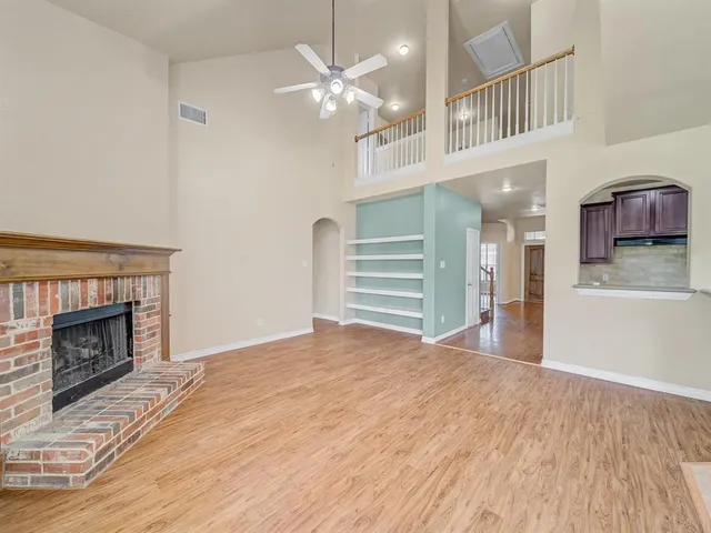 a view of a livingroom with a fireplace a chandelier and stairs