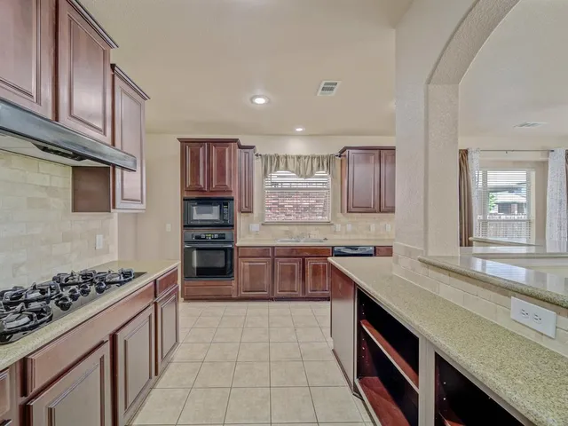 a kitchen with stainless steel appliances granite countertop a stove and a sink