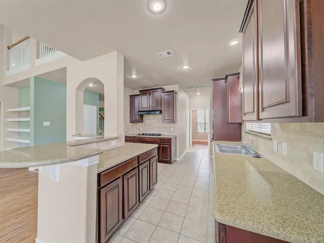 a large kitchen with stainless steel appliances granite countertop a large counter top and a stove