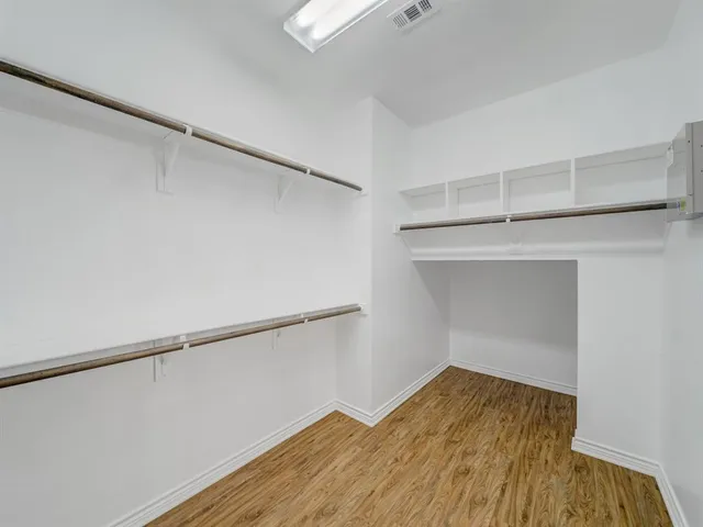 a view of a room with wooden floor and white walls