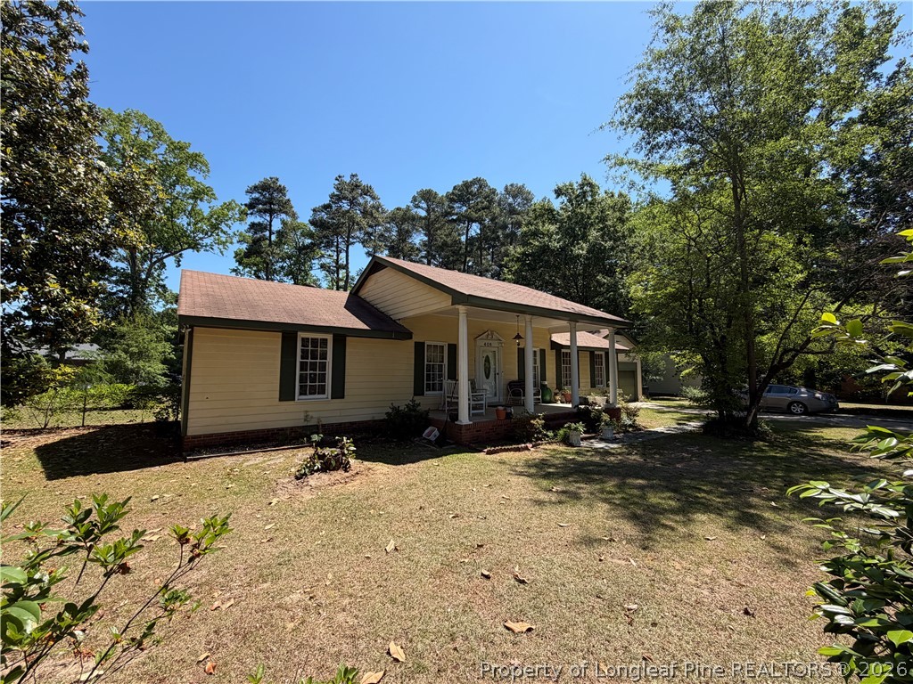 408 Old Farm Road Raeford, NC 28376 - Photo 2 of 27 a front view of a house with a yard covered with snow and trees