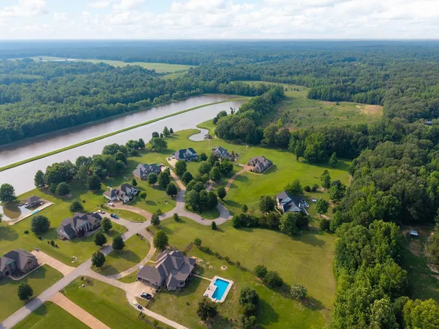 an aerial view of lake and residential houses with outdoor space